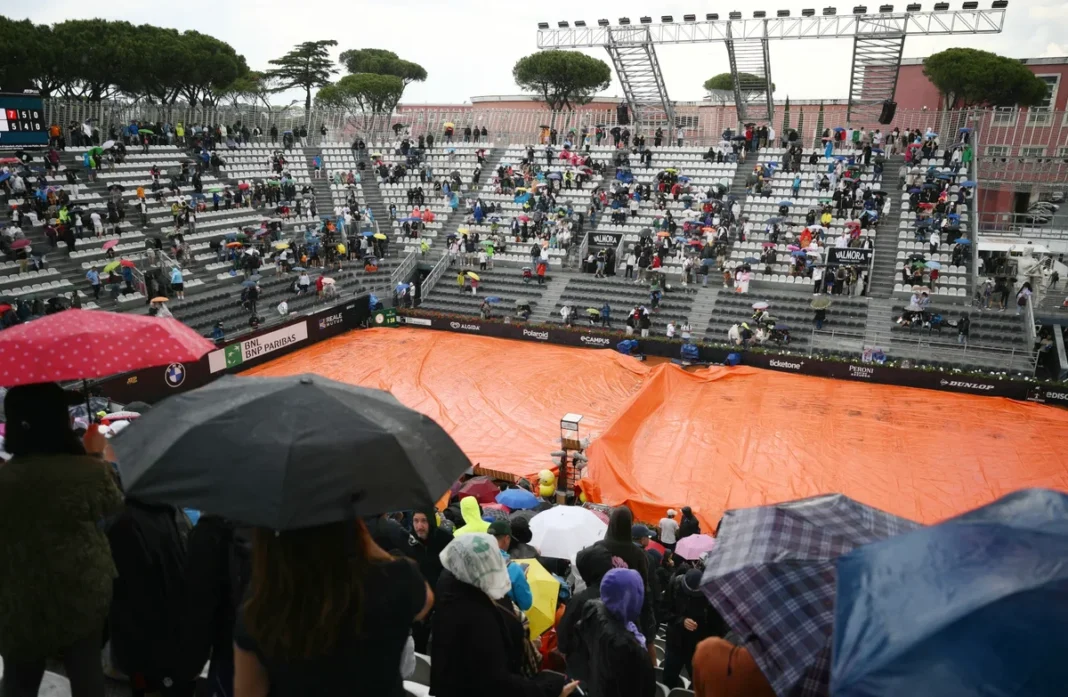 Quadra central de tênis em Roma coberta por lona laranja devido à chuva.