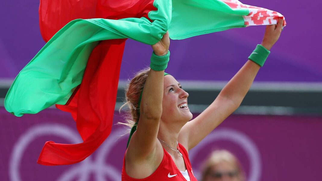 Viktoria Azarenka sorrindo em quadra, representando a bandeira da Bielorrússia, após bronze em Londres 2012.