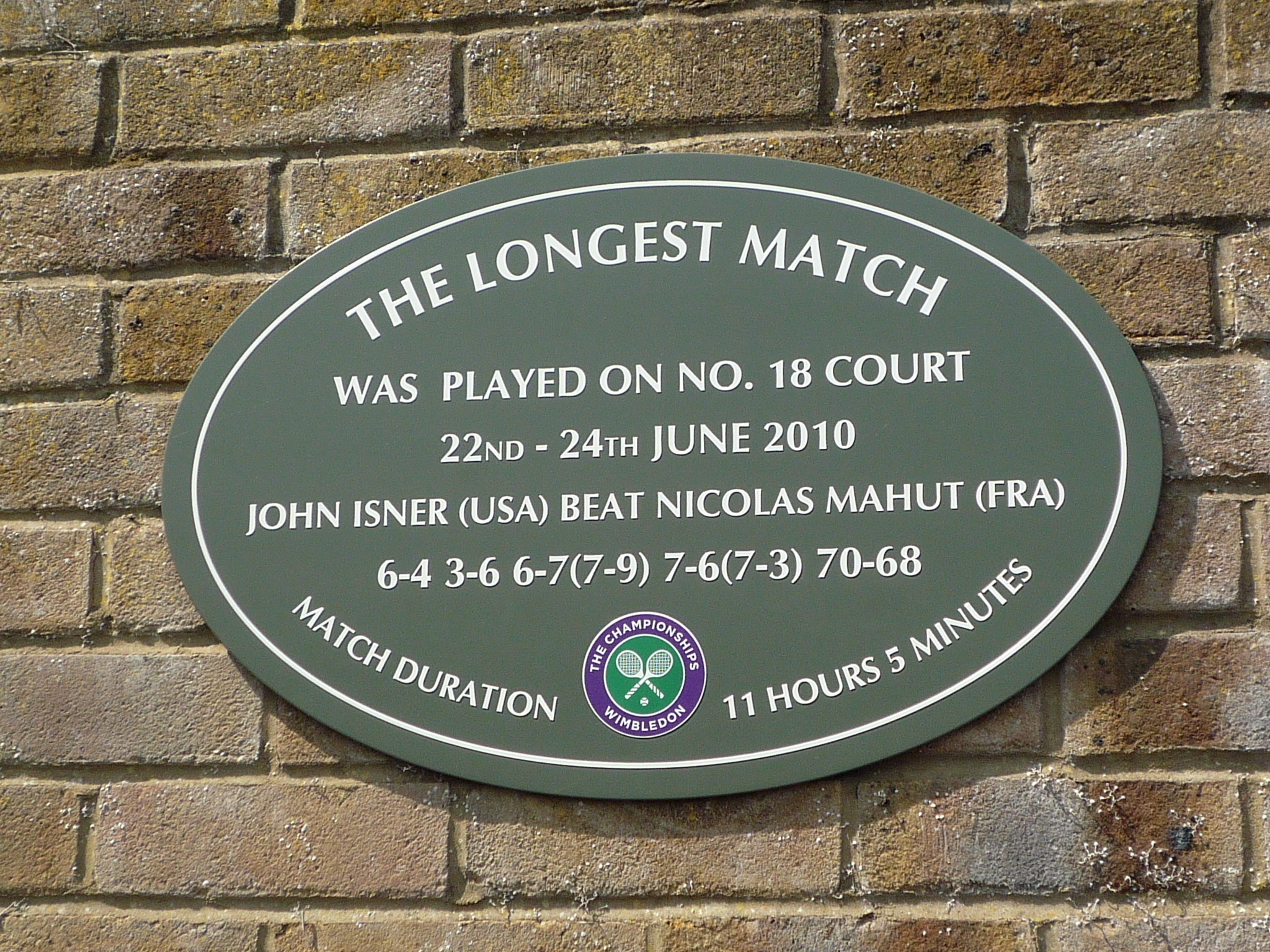 Placa instalada na Quadra 18 de Wimbledon para homenagear o jogo mais longo da história do tênis, disputado entre John Isner e Nicolas Mahut de 22 a 24 de junho de 2010.
